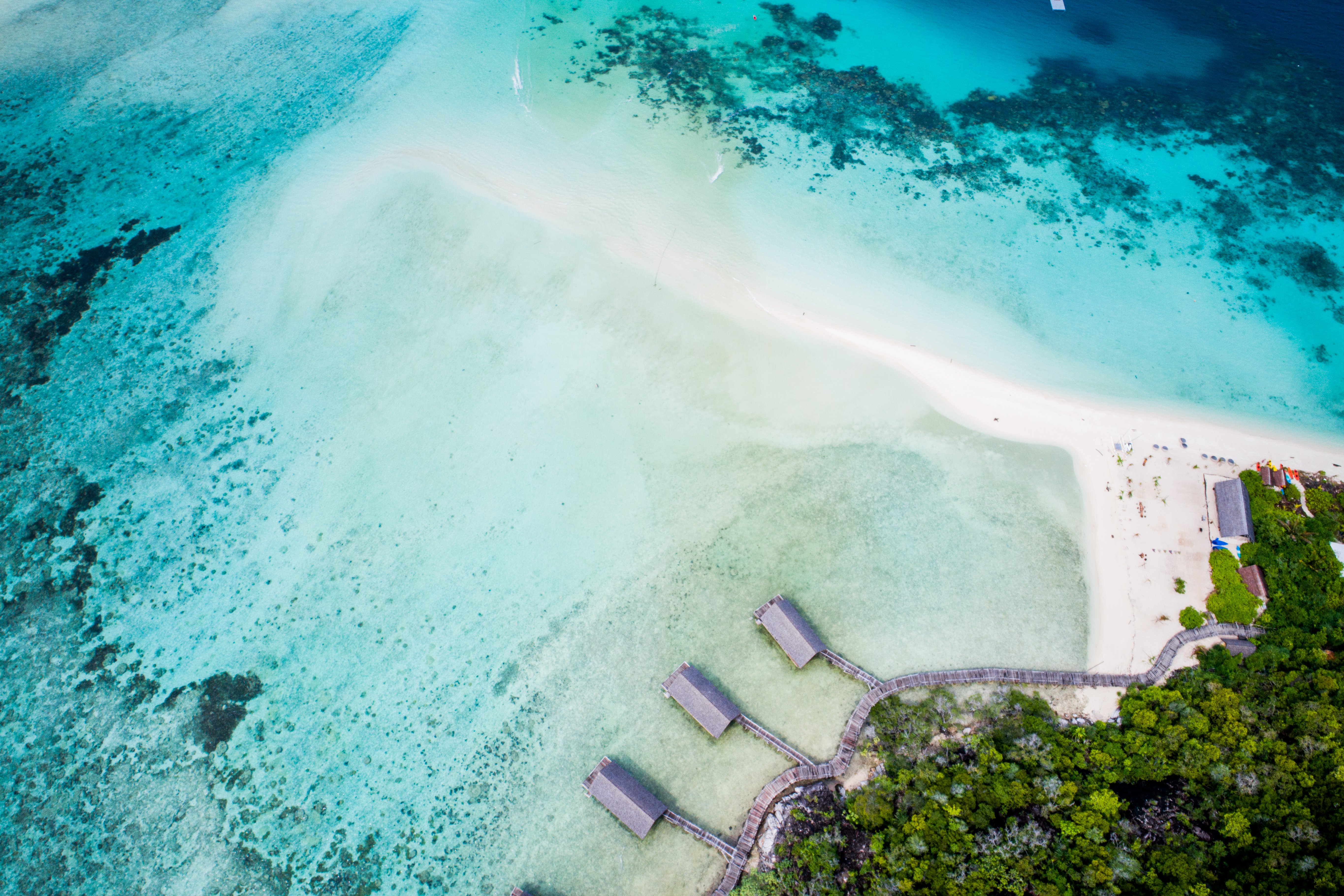 aerial_east_overwater_suites_boat_house_sandy_beach_green_forest_backgroundjpg
