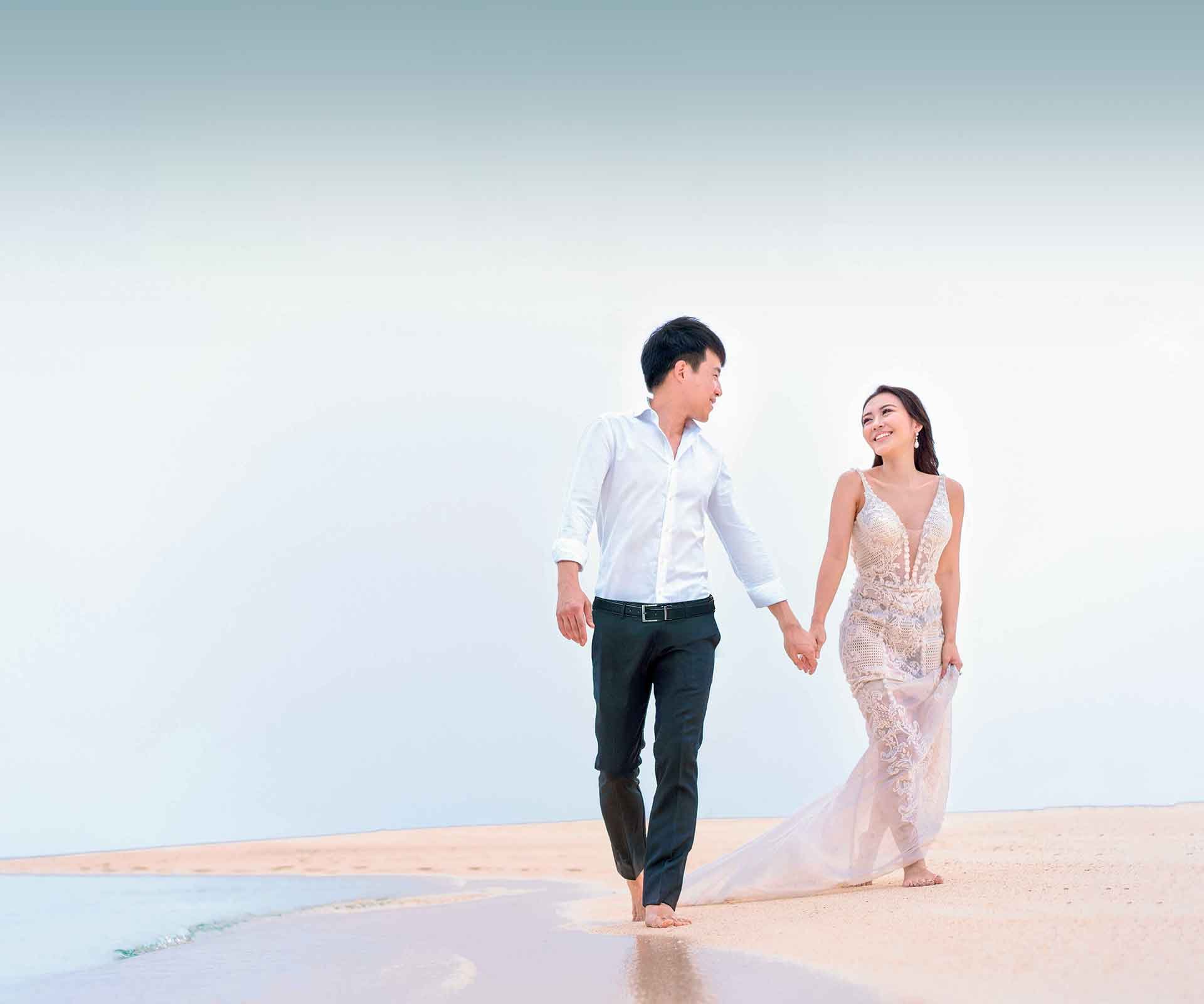 gradient_male_female_wedding_couple_walking_along_beach_pink_hour-3