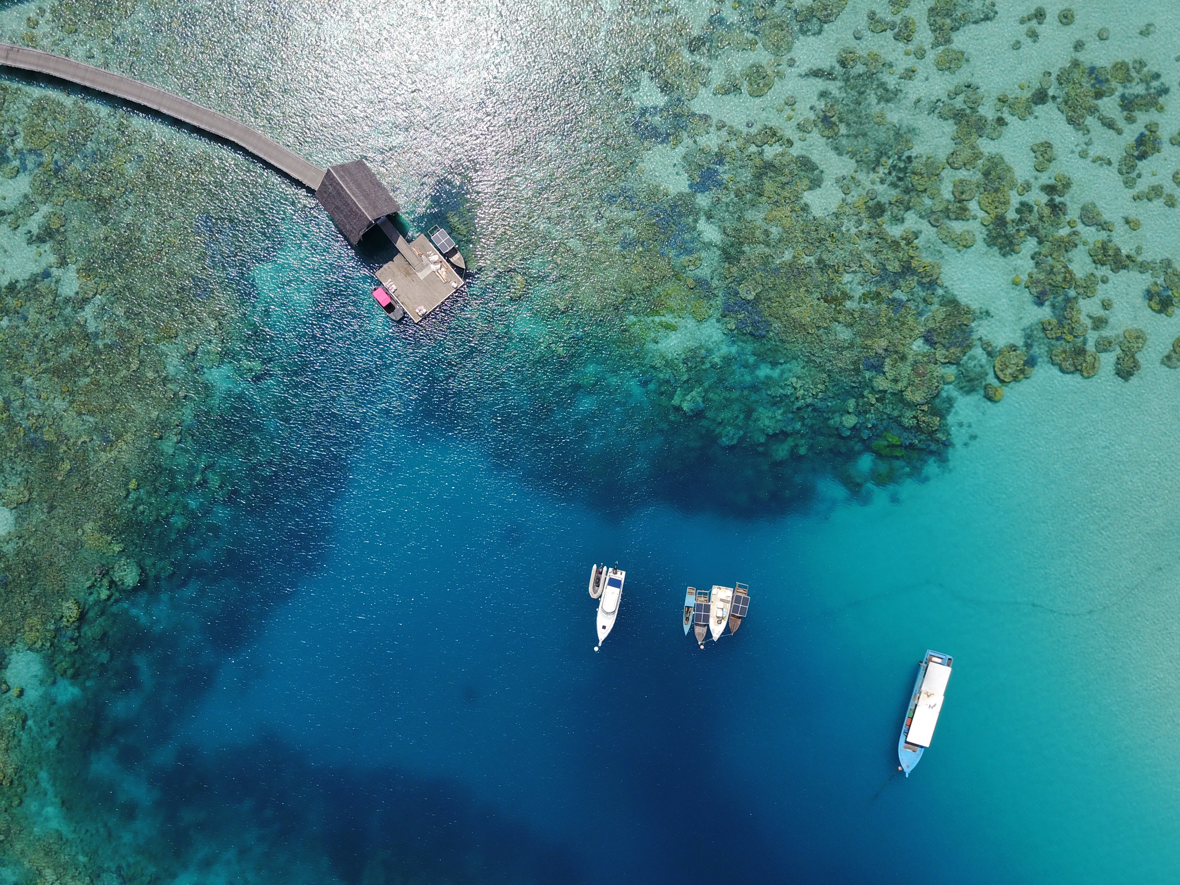 aerial_boats_in_coral_reefs_lagoon_jetty_thatched_roof (2)