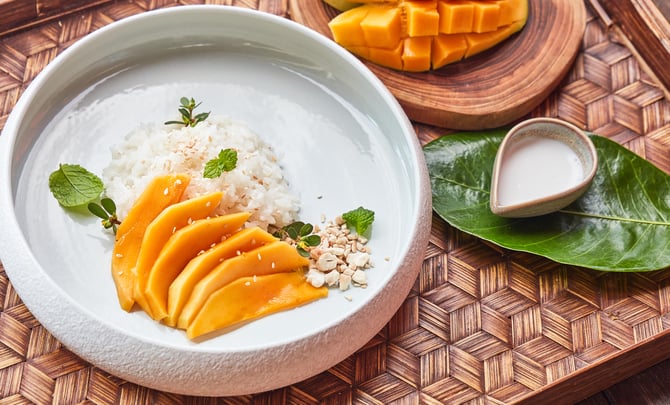 mango_sticky_rice_with_coconut_milk_on_wooden_tray