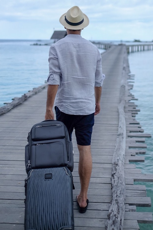 Man leaving Bawah Reserve with suitcase on the jetty